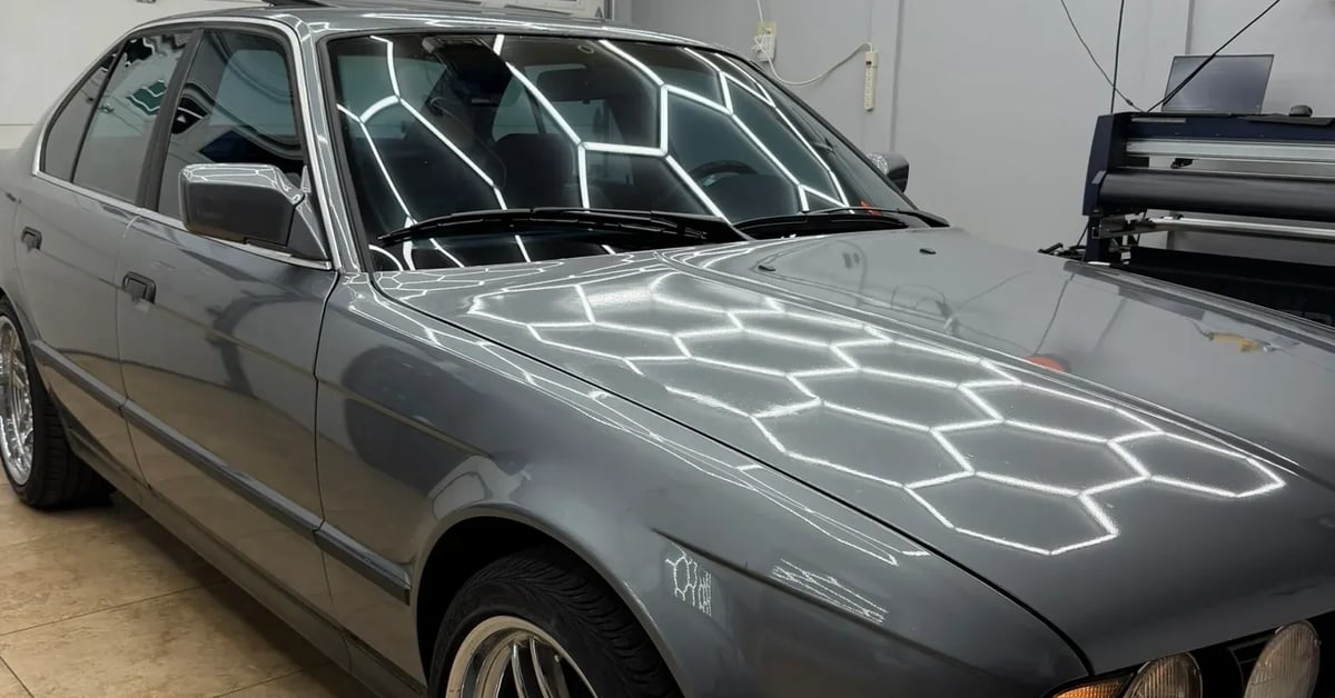 Polished gray BMW after professional ceramic window tinting in clean-room studio