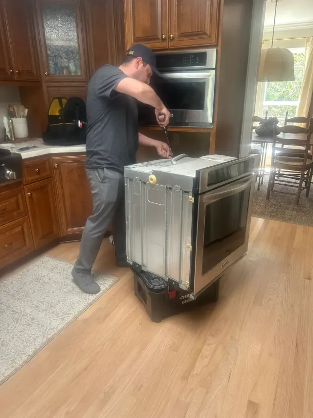 Technician repairing a built-in oven
