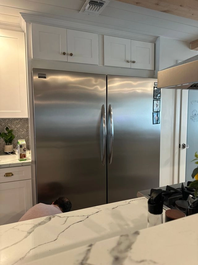 Refrigerator repair work in progress in a kitchen