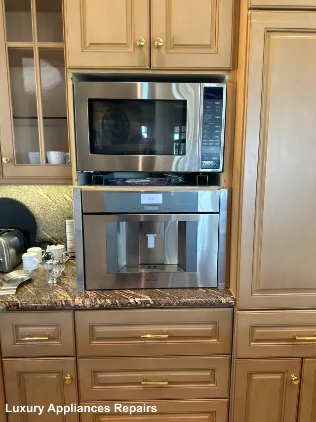 Built-in stainless steel microwave and coffee machine installed in luxury wood cabinets.