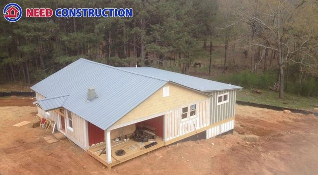 Aerial view of a new home construction project with a metal roof by Need Construction.