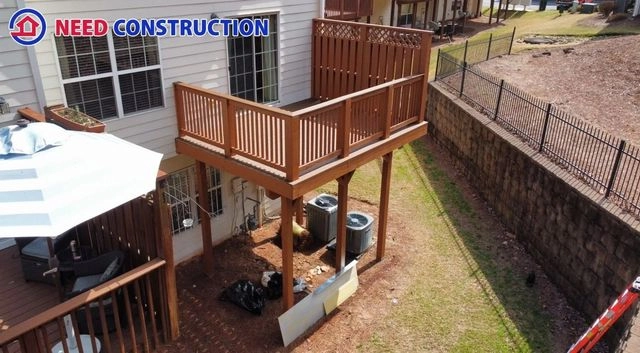 A high-angle shot of a finished elevated wooden deck with a privacy wall on a multi-family home.