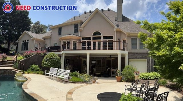 A luxury home with a large deck, covered patio, and swimming pool in a landscaped backyard.