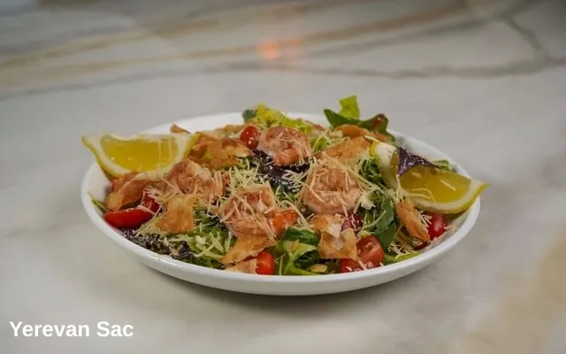 A white bowl filled with a vibrant salad featuring grilled shrimp, mixed greens, cherry tomatoes, and crispy pita chips — Yerevan Sac, Carmichael CA