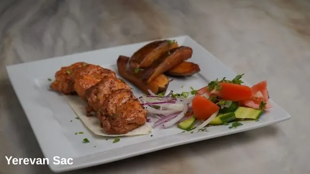 A beautifully plated dish from Yerevan Sac featuring succulent grilled chicken kebabs served on a piece of flatbread