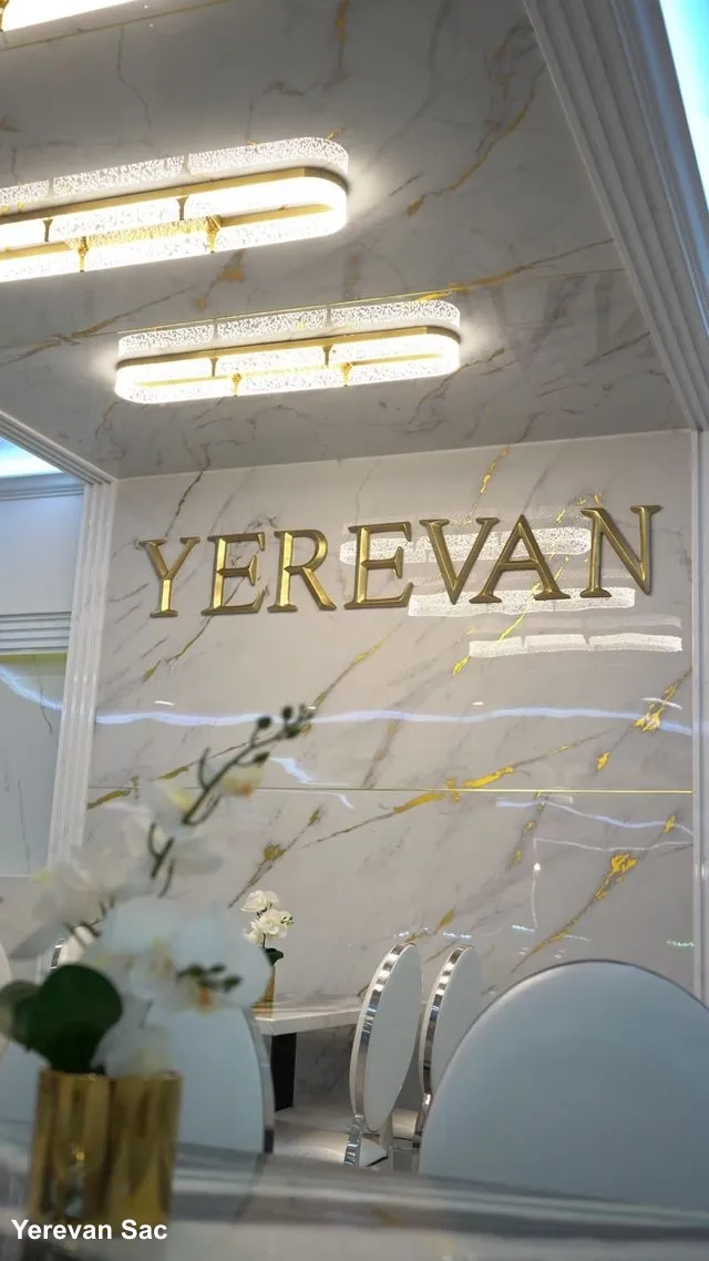 A high-end restaurant interior featuring a white marble wall with gold veining and the name 'YEREVAN' in large gold letters — Yerevan Sac, Carmichael CA